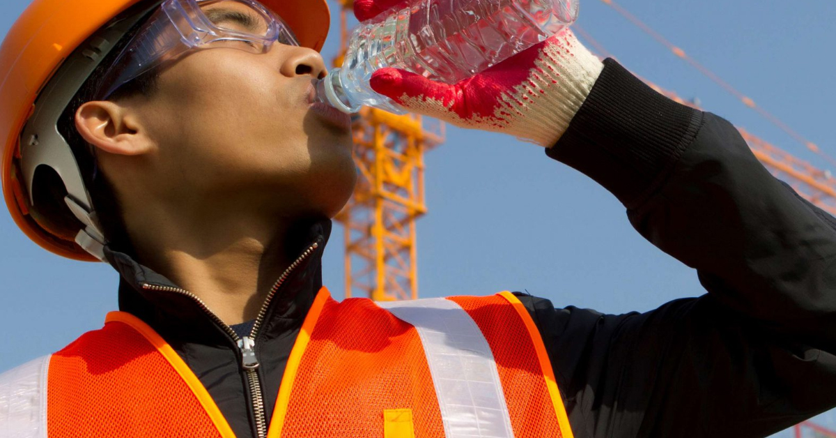 employee wearing safety vest drinking an electrolyte water