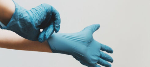 hands putting on nitrile gloves