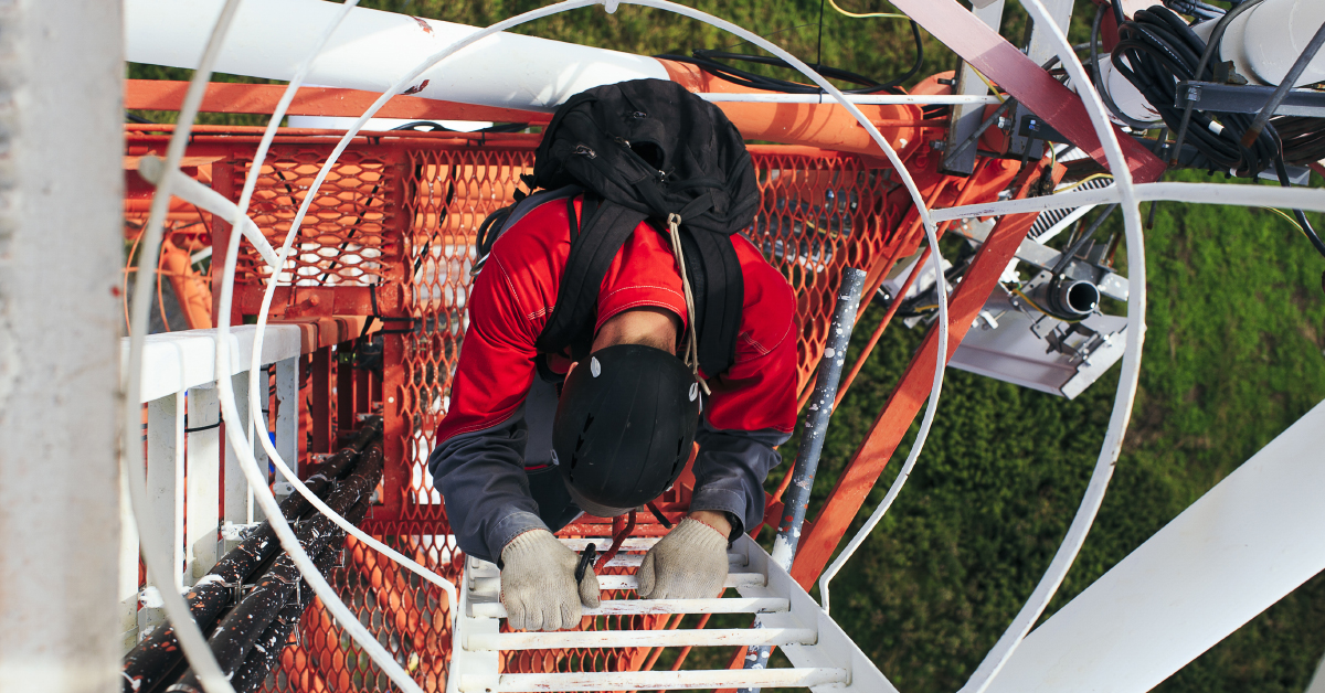 employee climing ladder at construction site wearing safety gloves