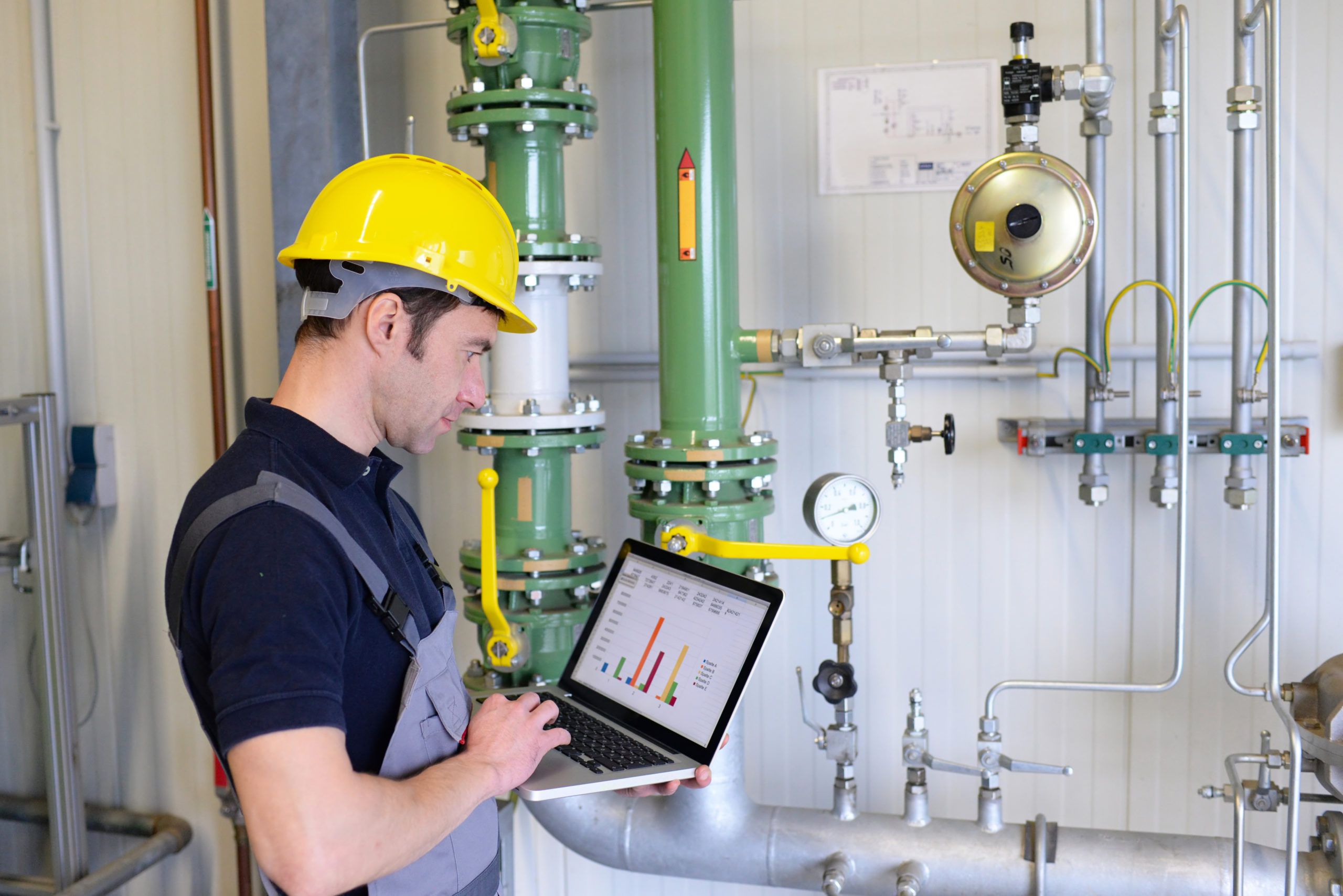 Workers maintaining a modern industrial plant - checking and recording data