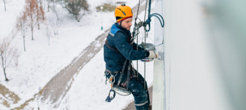 safety employee at height using fall protection in the snow