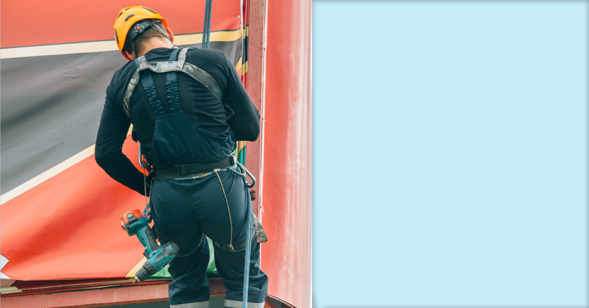 Employee at height climbing billboard