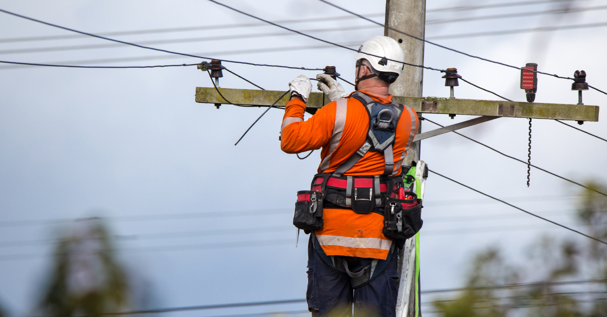 safety employee at height fixing powerline