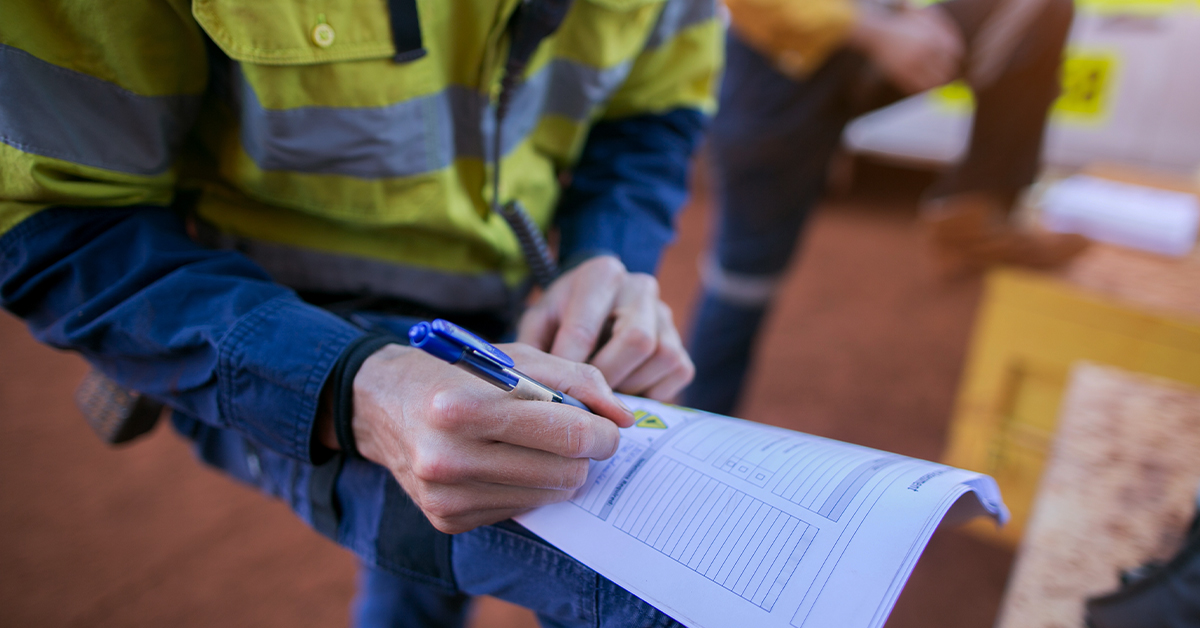 employee with clipboard accessing safety strategy