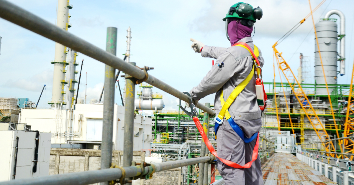 Employee in fall protection on top of scaffolding at construction site