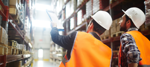 Safety director in warehouse pointing at inventory