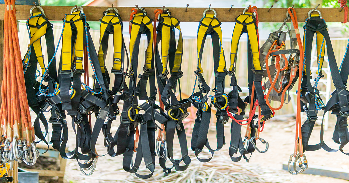 Row of used fall protection harnesses hanging at jobsite