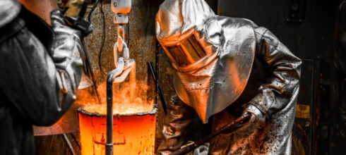 worker wearing aluminized heat-resistant ppe gear in foundry