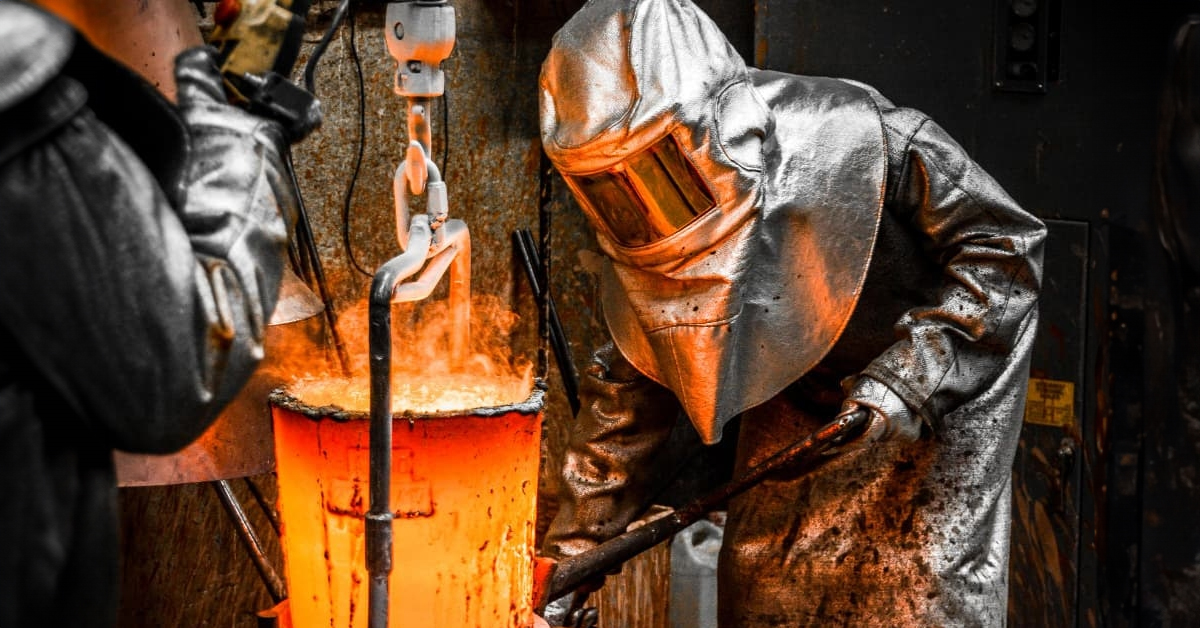 worker wearing aluminized heat-resistant ppe gear in foundry