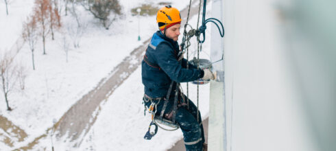 safety employee at height using fall protection in the snow