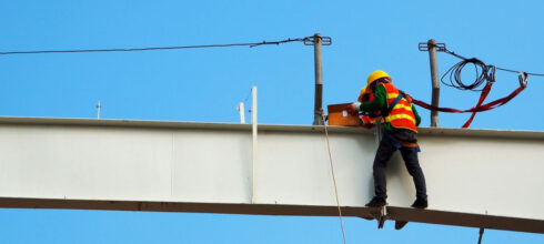 worker at height on metal beam in fall protection