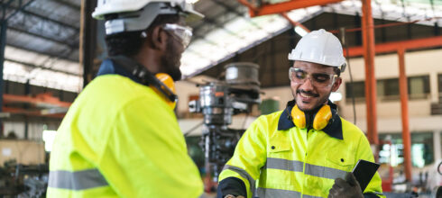 New Safety employee being onboarded in manufacturing facility wearing full PPE