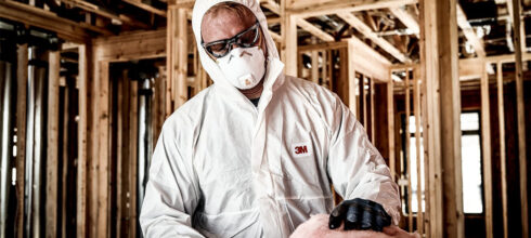 employee in full respiratory safety protection at construction site