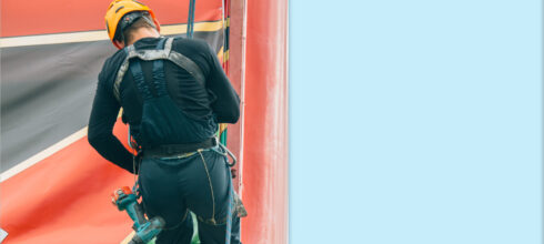 Employee at height climbing billboard