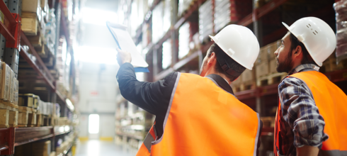 Safety director in warehouse pointing at inventory