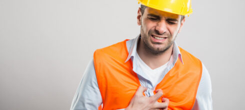 Employee in safety vest and hard hat having stroke