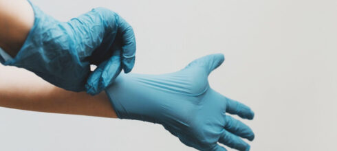 hands putting on nitrile gloves