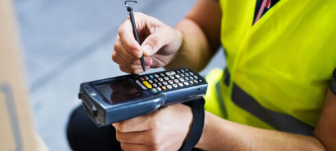 safety employee with technology in storeroom taking inventory