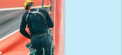 Employee at height climbing billboard